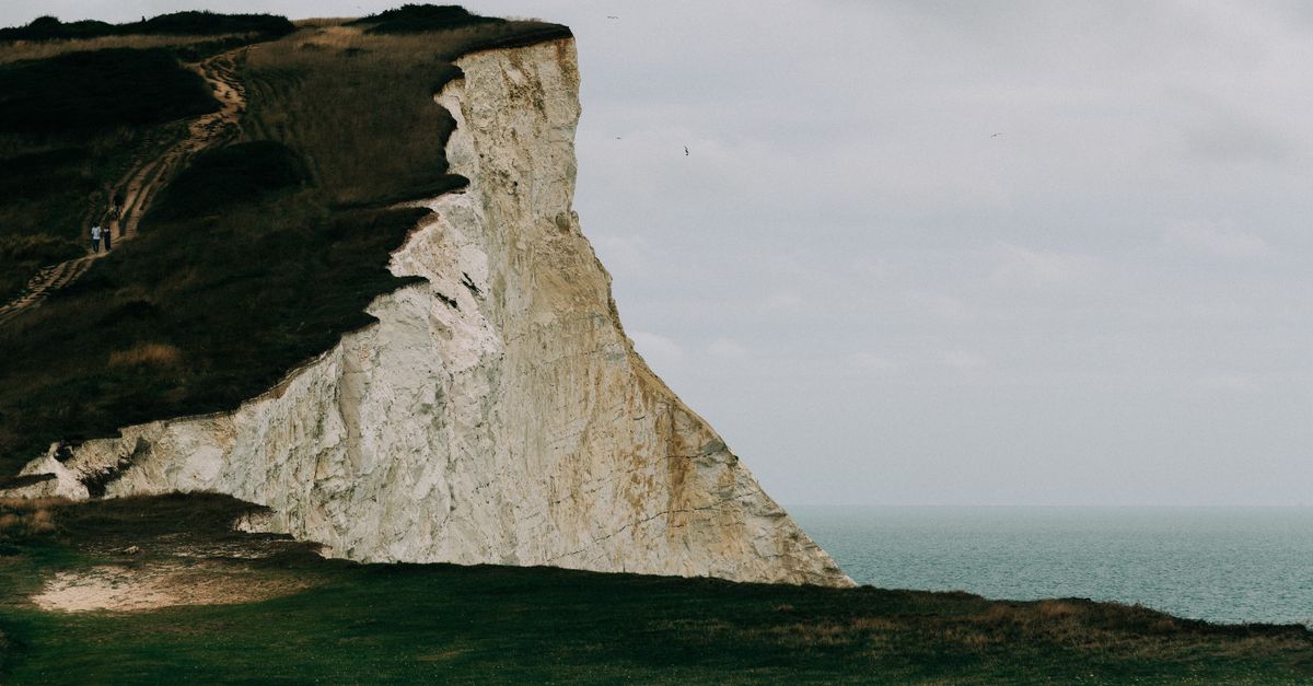 The iconic White Cliffs of Dover overlooking the English Channel on a cloudy day, captured from a scenic viewpoint.